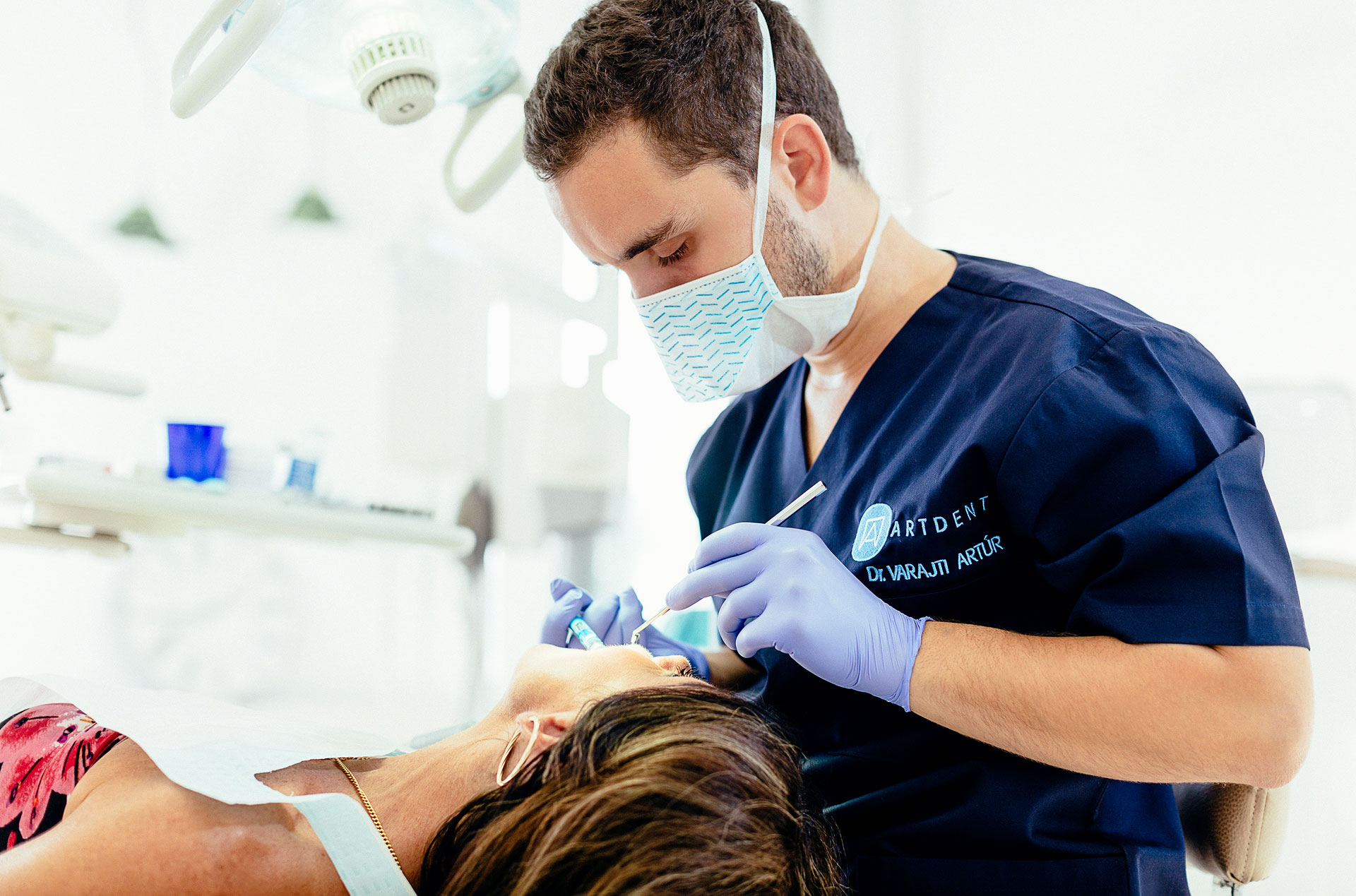 A budapesti fogászati rendelőben a szájsebész implantációs műtét előtt érzéstlenítőt ad a páciensnek.