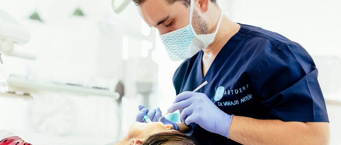 Dr. Varajti Artúr fogorvos, szájsebész érzéstelenítőt ad a pácienst a budapesti fogászati rendelőben.