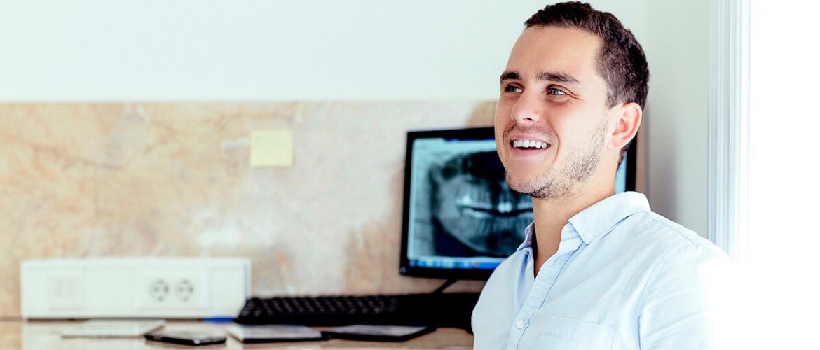 Dr. Varajti Artúr fogorvos, szájsebész ül és mosolyog.