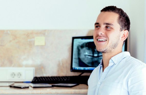 Dr. Varajti Artúr fogorvos, szájsebész ül és mosolyog.