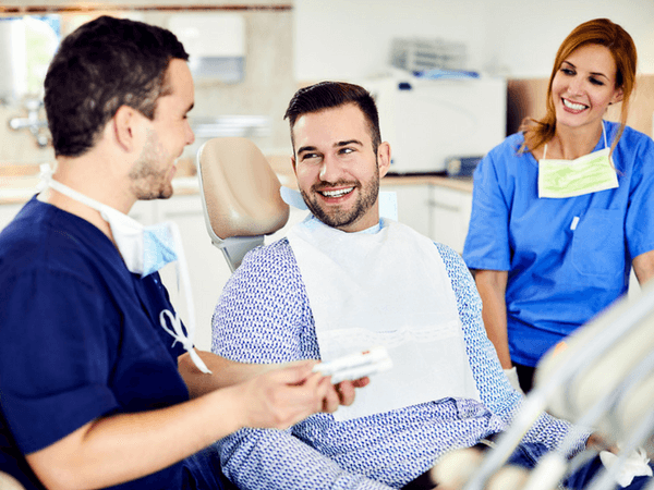 Dr. Varajti Artúr fogorvos és szájsebész és páciense beszélget fogkőeltávolítás után.