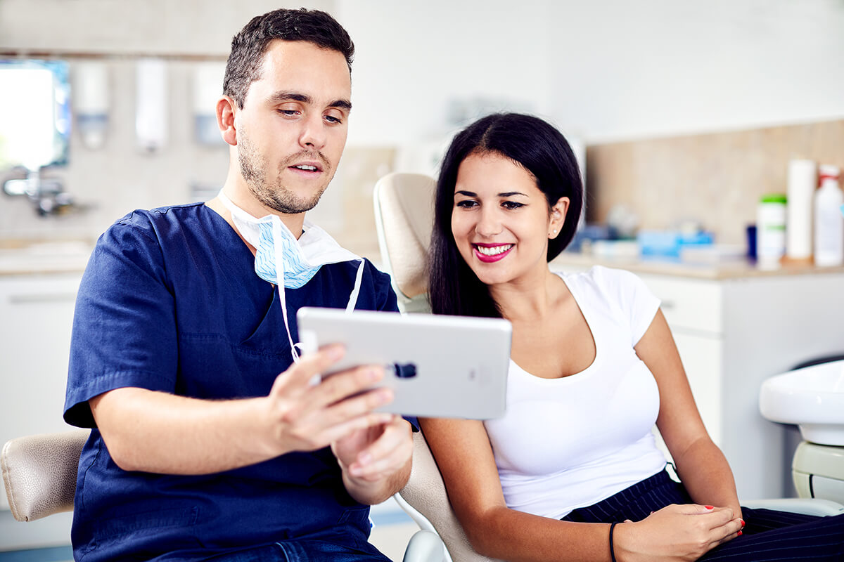 Dr. Varajti Artúr fogorvos és páciense bölcsességfog eltávolítás elött konzultál budapesti fogászati rendelőben.