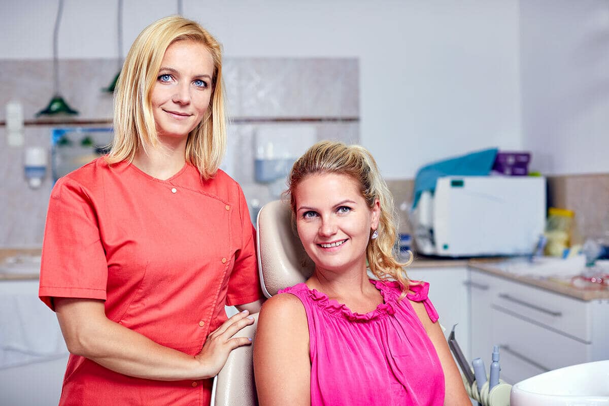 Dr. Friedreich Dóra, az Artdent fogszabályozó szakorvosa és a páciense egymás mellett állnak és mosolyognak a fogszabályozást megelőző konzultáció után.