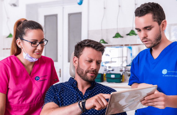 Dr. Ökrös Petra és Dr. Varajti Artúr fogorvos ultrahangos fogkő-eltávolítás után konzultálnak a pácienssel.