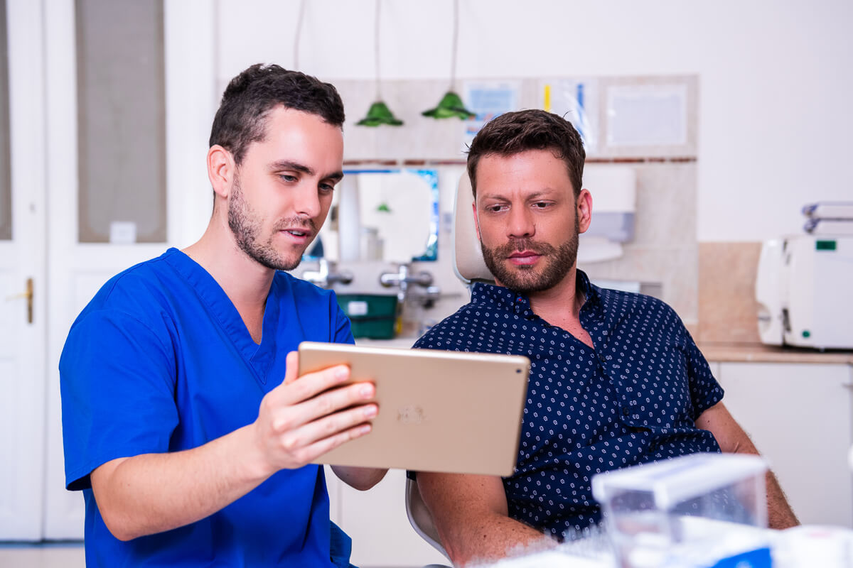 Dr. Varajti Artúr egy foghiány miatti fogbeültetés előtti konzultáción az Artdent Fogászat páciensével