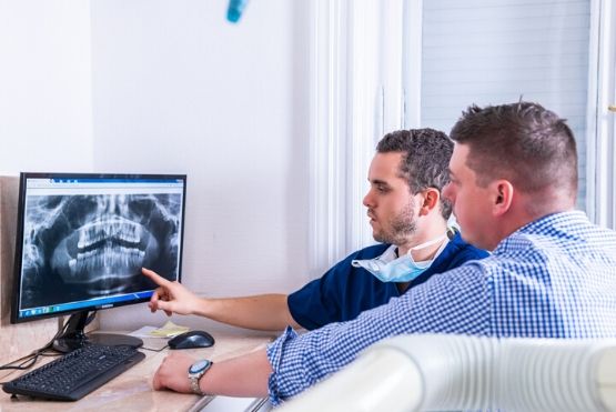 Gyökérkezelés előtt Dr. Varajti Artús és páciense konzultál.