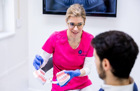 Dr. Tussinger Mónika fogszabályozási utáni teendőkről beszél a pácienssel.