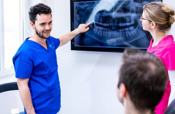 Dr. Varajti Artúr és Dr. Tussinger Mónika egyeztet a pácienssel a budapesti fogászati rendelőben.