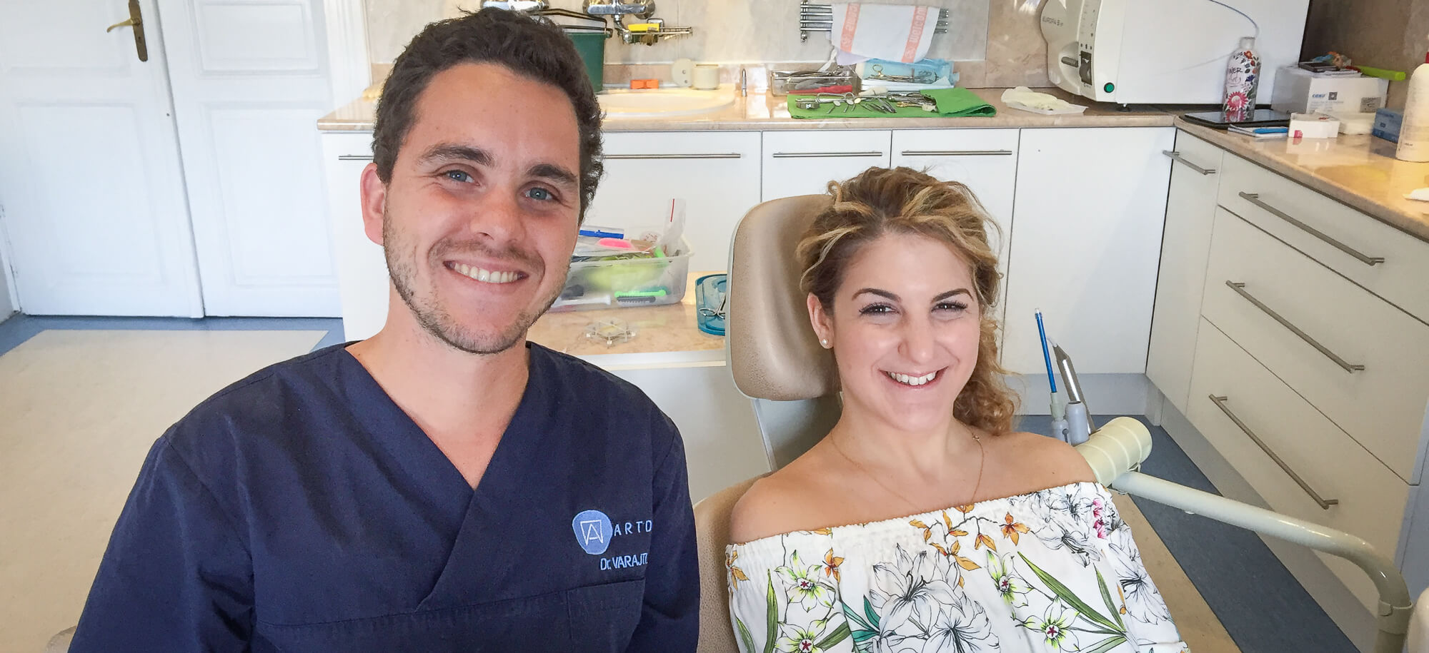 Dr. Varajti Artúr szájsebész és fiatal hölgy páciense mosolyog bölcsességfog eltávolítás után.