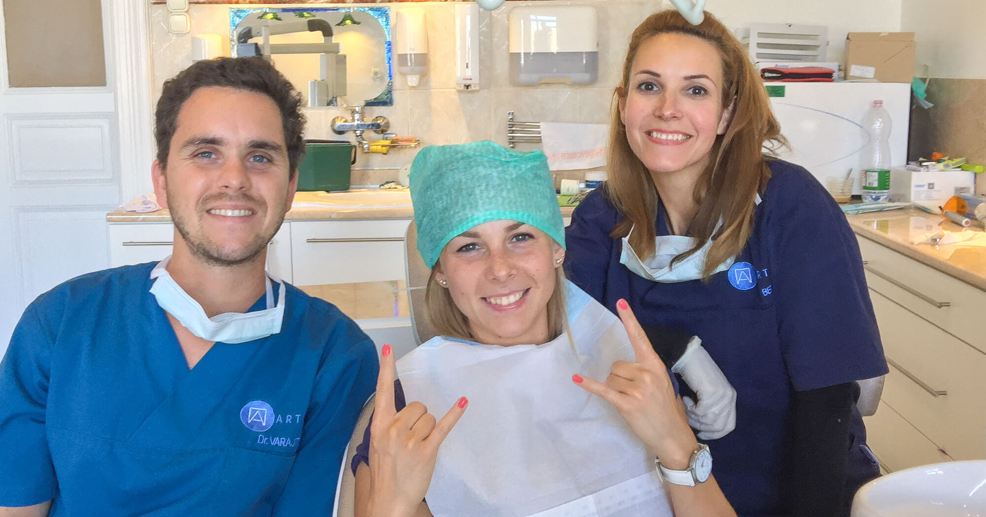 Dr. Varajti Artúr szájsebész, asszisztense és páciense mosolyog bölcsességfog műtét után.